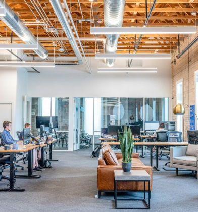 man in blue dress shirt sitting on rolling chair inside room with monitors
